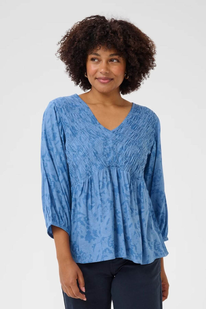 Chemisier en coton bleu, avec col en V et manches 3/4, idéal pour un look décontracté et léger.