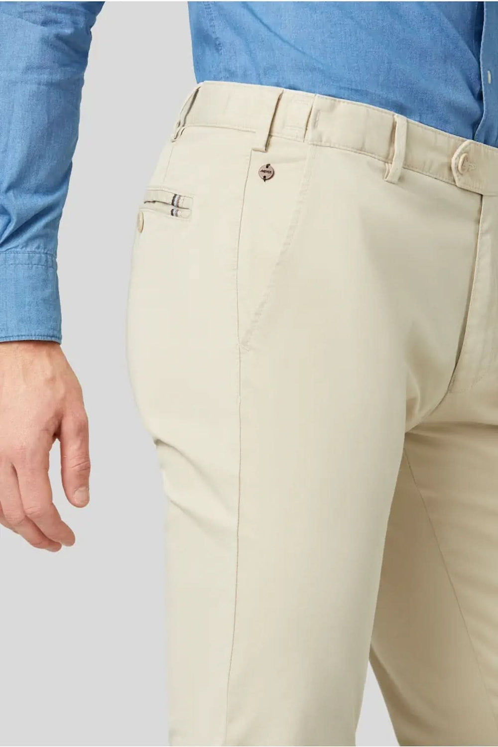 Pantalon Chino flex beige, coupe droite, avec taille élastique et tissu extensible, porté avec une chemise bleue.