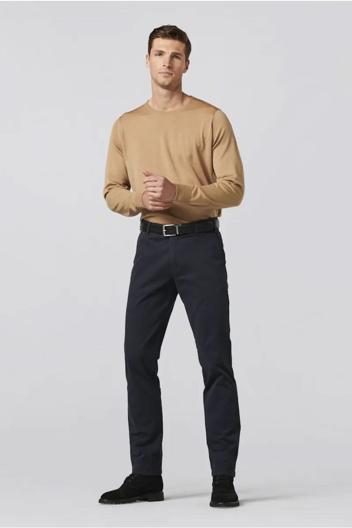 Homme en pull beige et pantalon chino flex bleu marine, alliant confort et style.