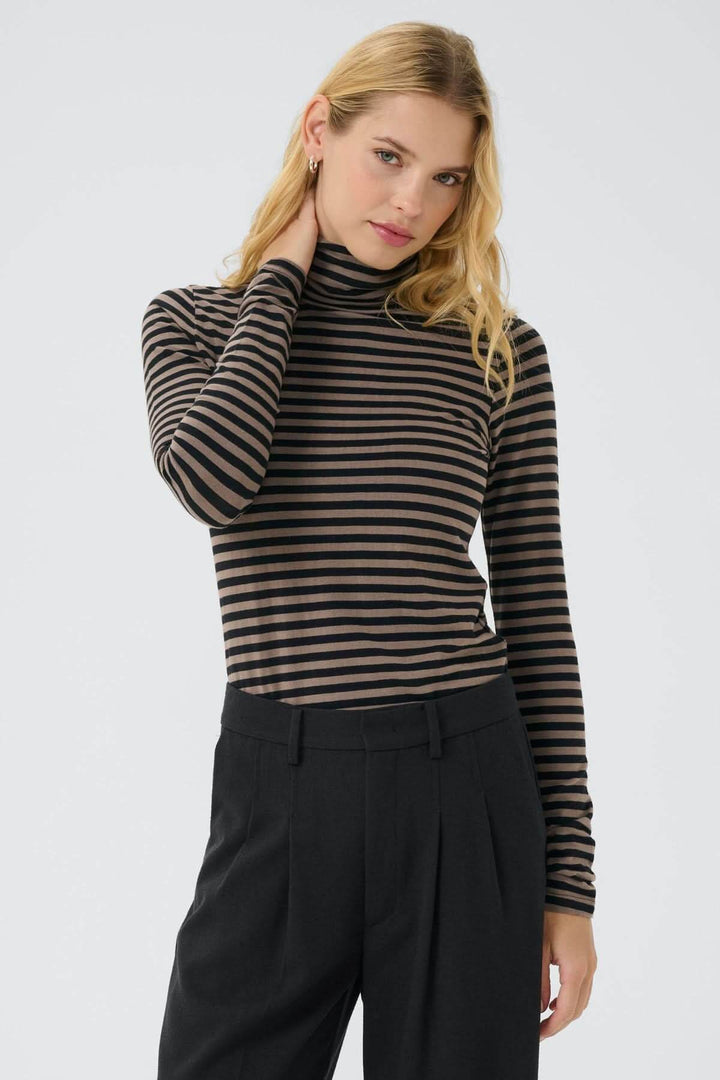 Femme portant un col roulé Efinas avec rayures noires et marron, manches longues, coupe ajustée, élégant et intemporel.