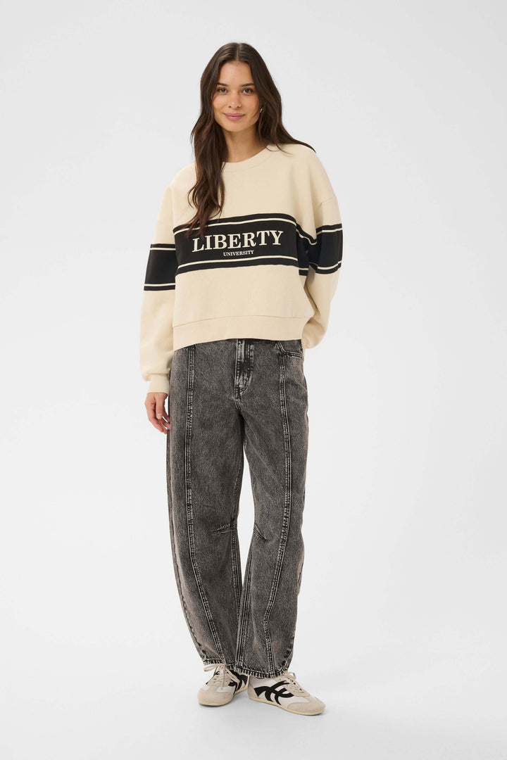 Femme portant le coton ouaté Assia avec motif graphique "Liberty", tenue décontractée et contemporaine pour un look urbain tendance.