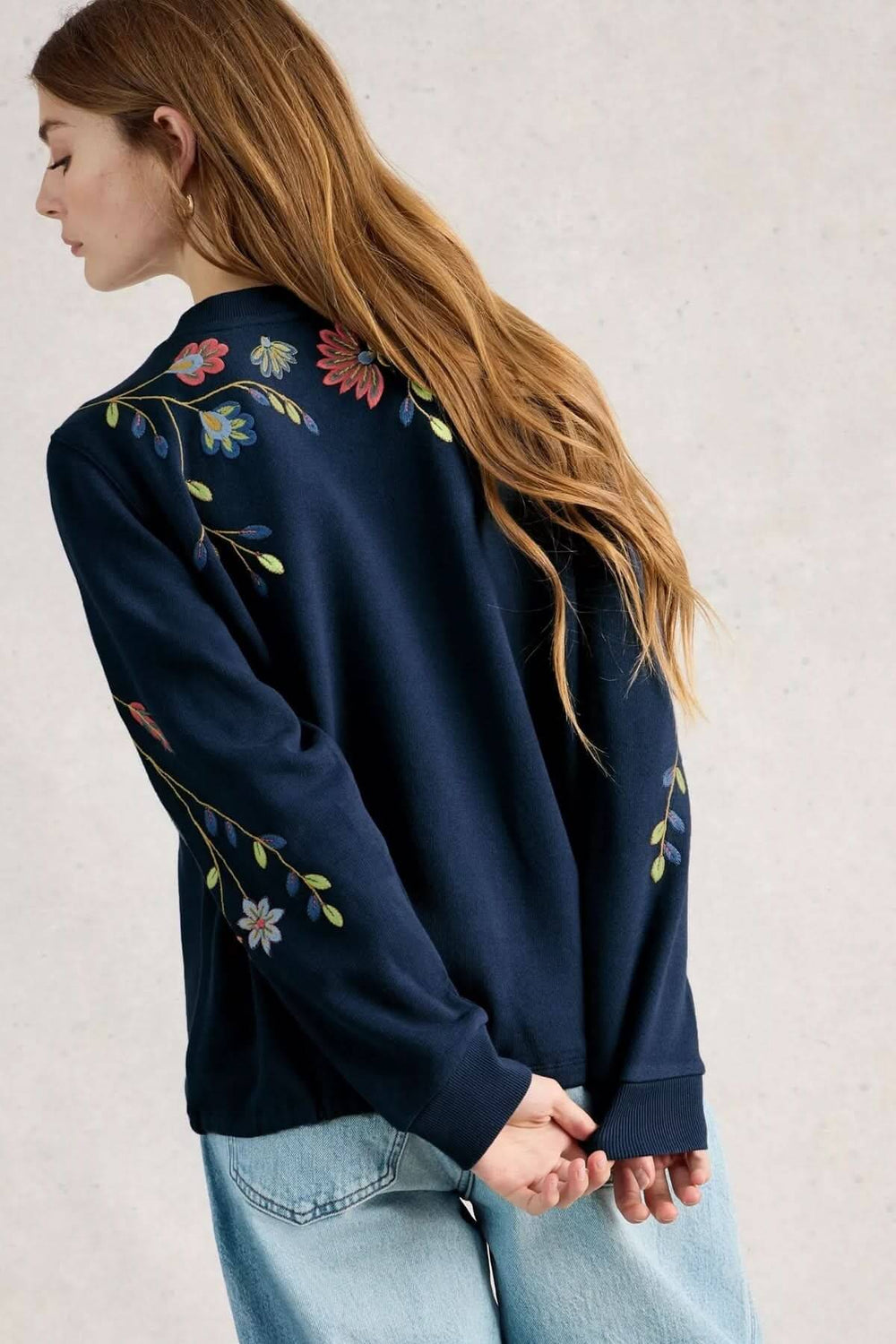 Femme portant un coton ouaté à broderie florale bleu marine, style décontracté, élégant et moderne pour la mi-saison.