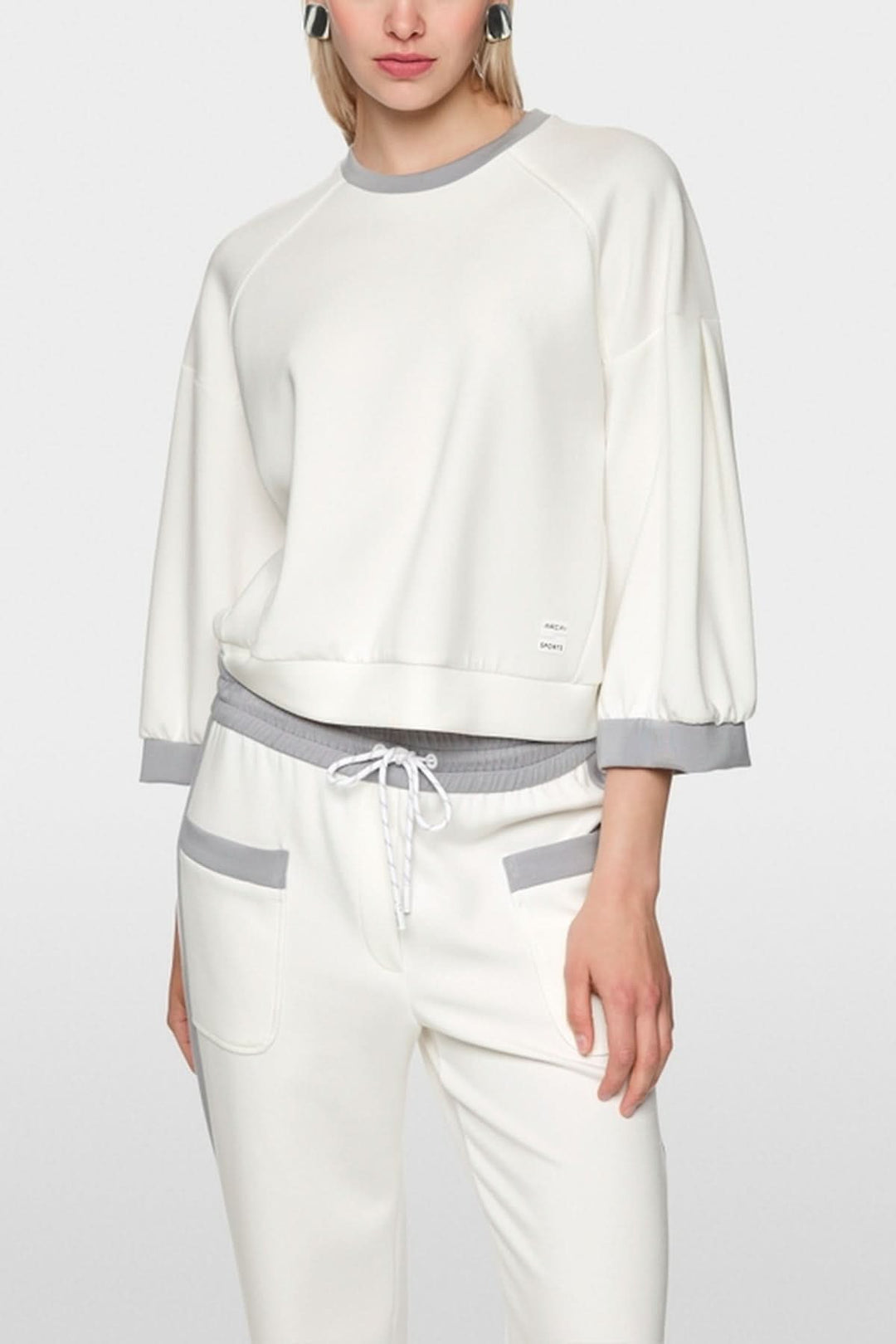 Coton ouaté décontracté blanc avec manches bouffantes et coutures contrastées, parfait pour un style sportif et décontracté.