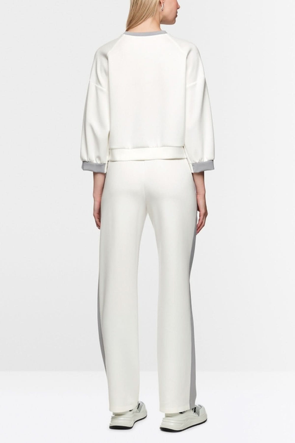 Femme portant un coton ouaté décontracté blanc avec manches bouffantes et coutures contrastées.