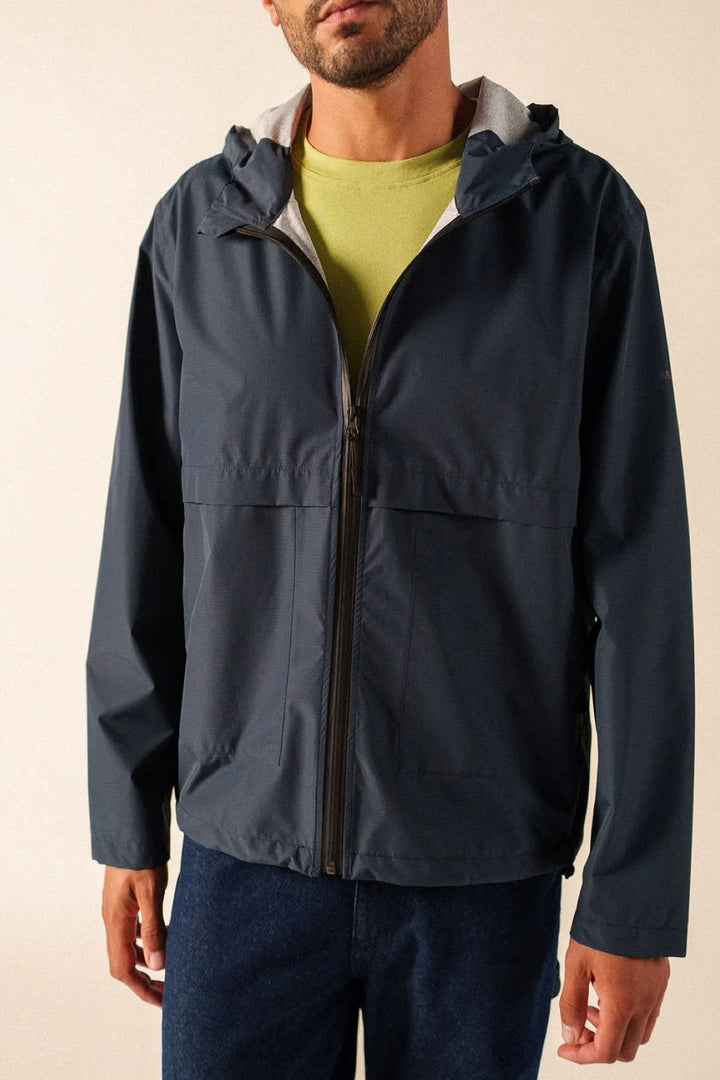 Homme portant un coupe-vent léger à fermeture zippée en noir, style décontracté et moderne, idéal pour temps frais.