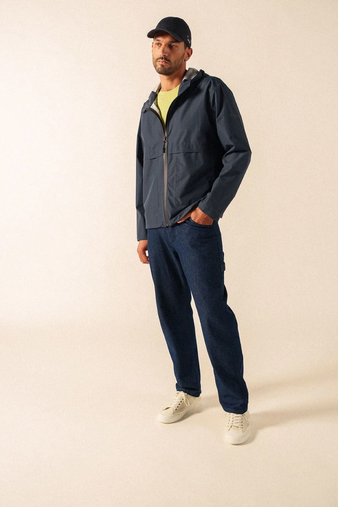 Homme portant un coupe-vent léger à fermeture zippée avec col montant, look décontracté et moderne.