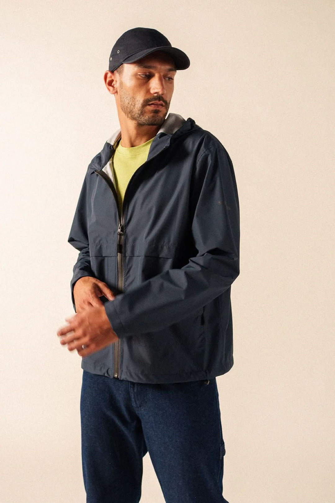 Homme portant un coupe-vent léger à fermeture zippée avec look sportif et moderne, idéal pour les journées fraîches ou venteuses.