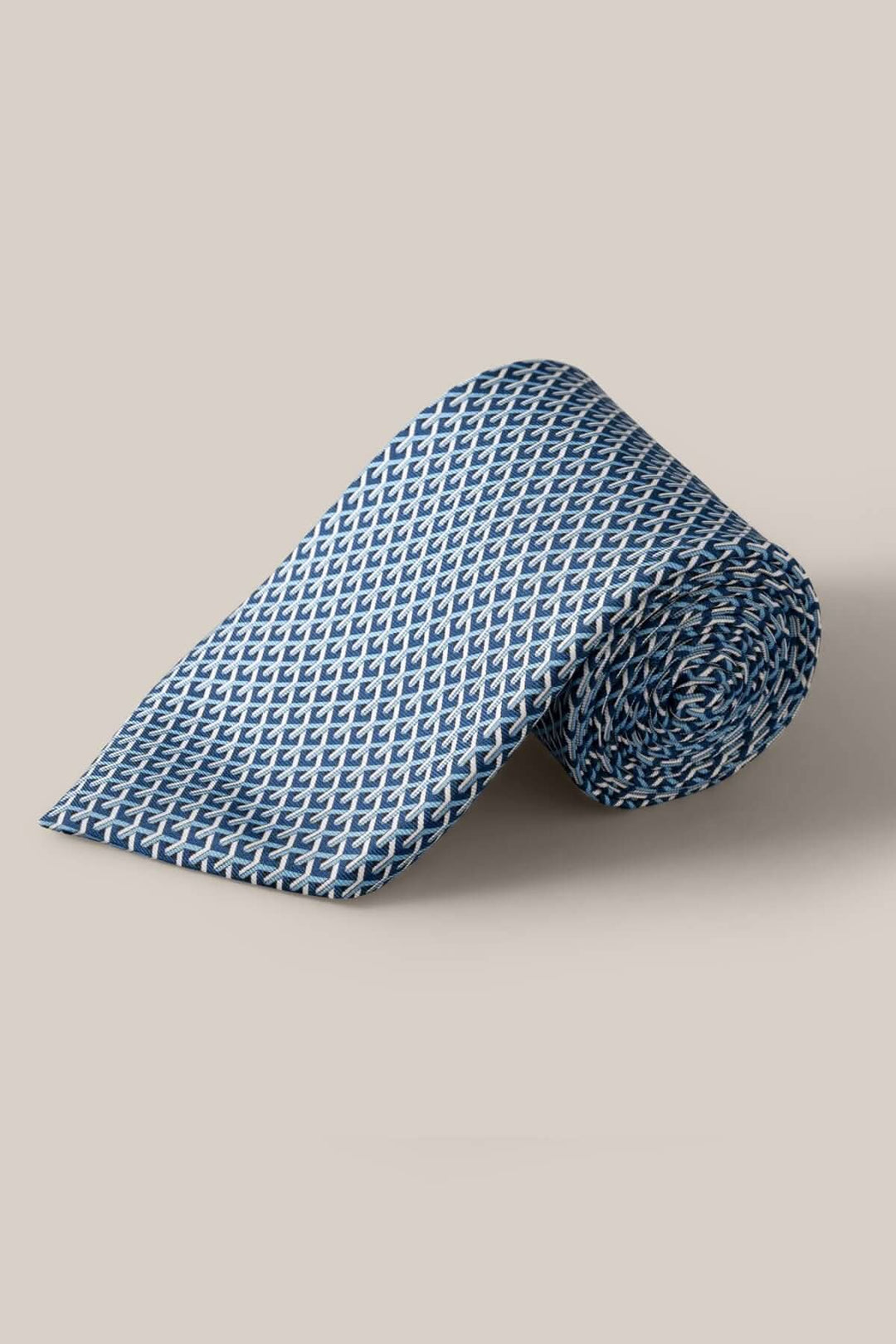 Cravate en soie bleue et blanche avec motif géométrique dynamique, parfaite pour une tenue habillée élégante.