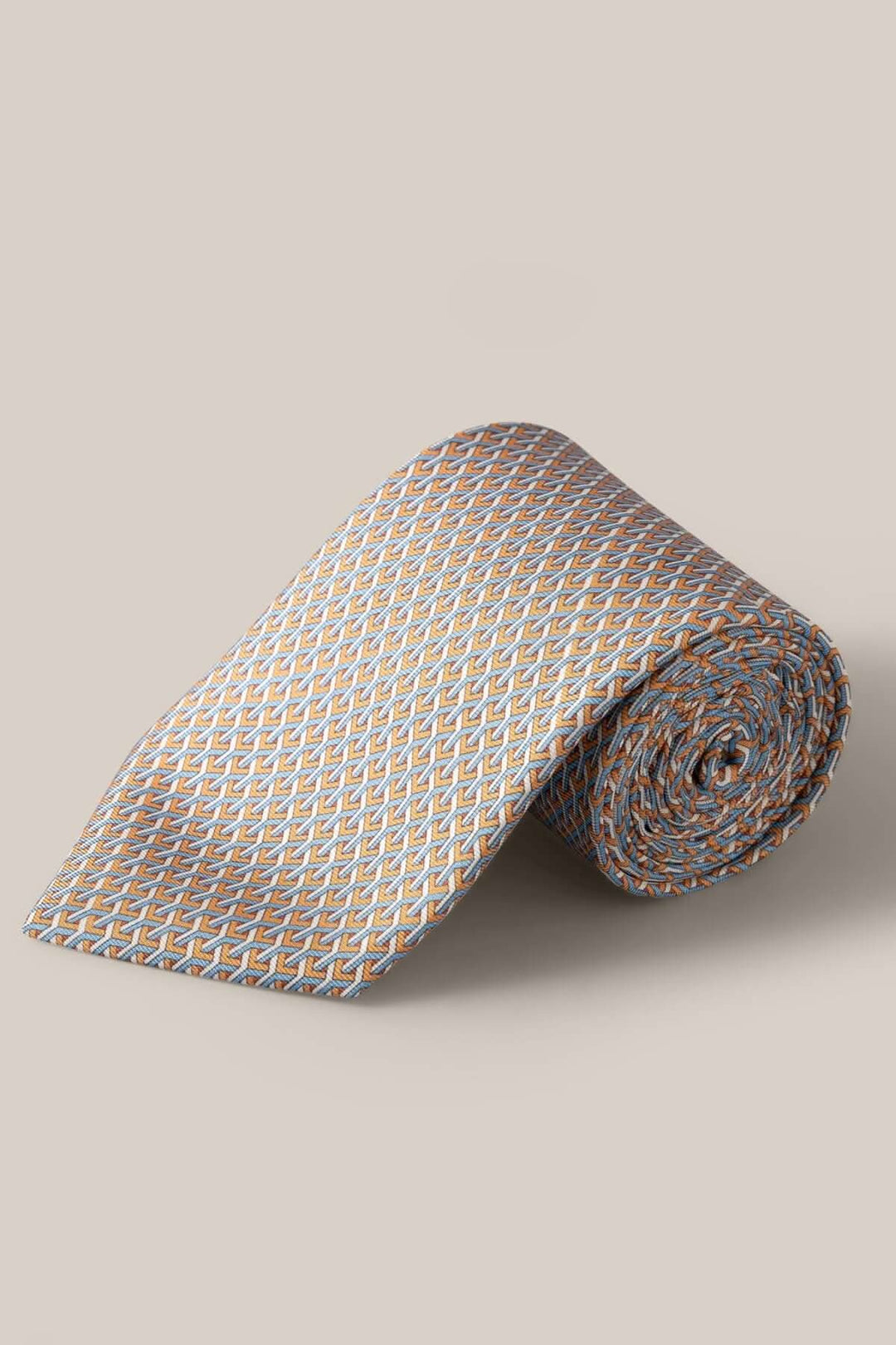 Cravate en soie à motif géométrique orange, bleu clair et blanc, enroulée, parfaite pour un look formel.