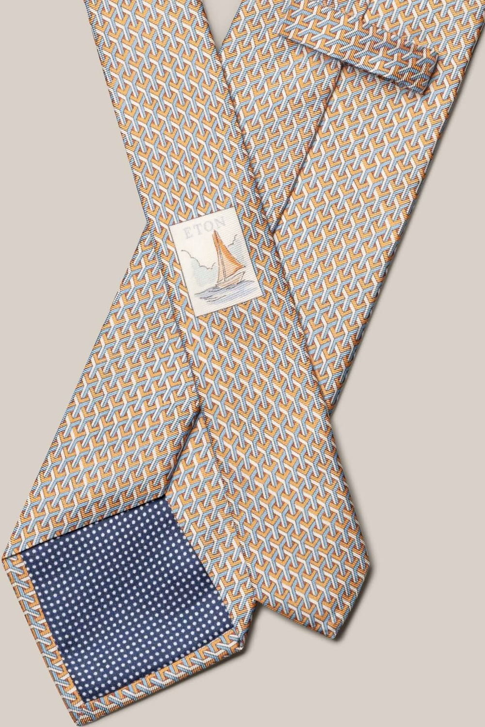 Cravate en soie à motif géométrique orange, bleu clair et blanc, style élégant et raffiné.