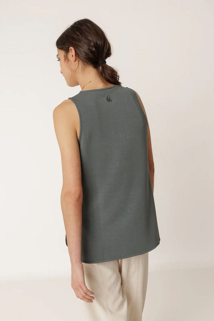 Vue arrière du débardeur minimaliste à coupe fluide porté par une femme, montrant la coupe ample et l'encolure dégagée.