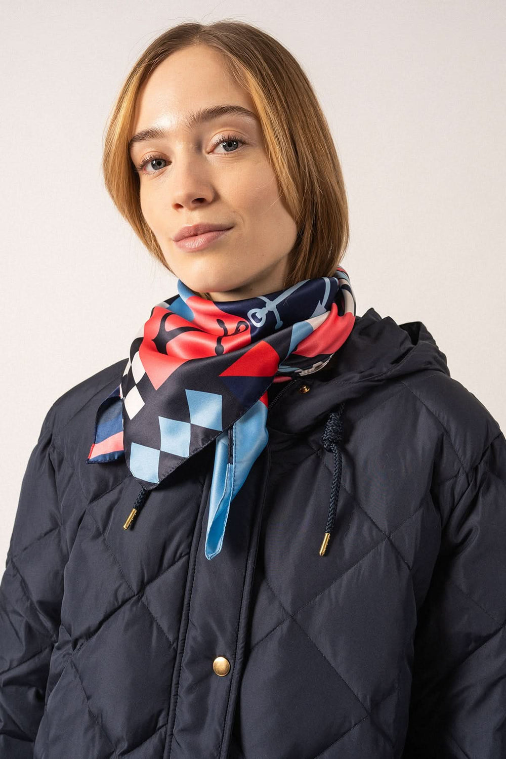 Foulard Carré Fond Marin porté par un modèle, style nautique, dimensions 90x90 cm, couleur vive et design élégant.