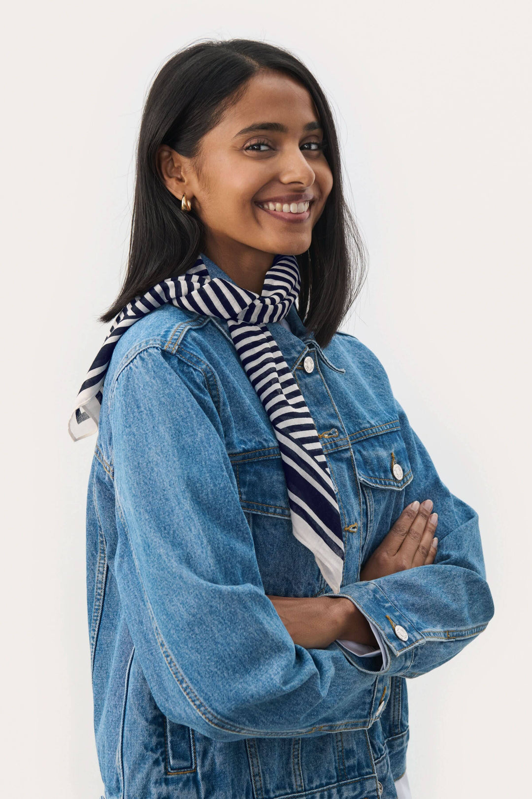 Foulard Phi élégant à motifs délicats porté par une femme souriante avec une veste en denim.