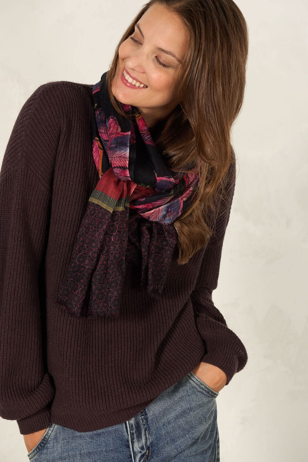 Foulard décoratif porté par une femme souriante, ajoutant une touche artistique à son look décontracté.