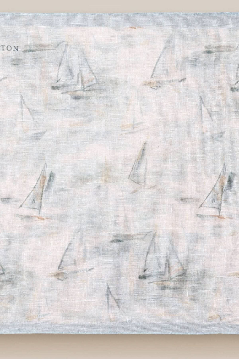 Foulard de poche en lin bleu avec motif de voiliers, idéal pour une touche nautique élégante.