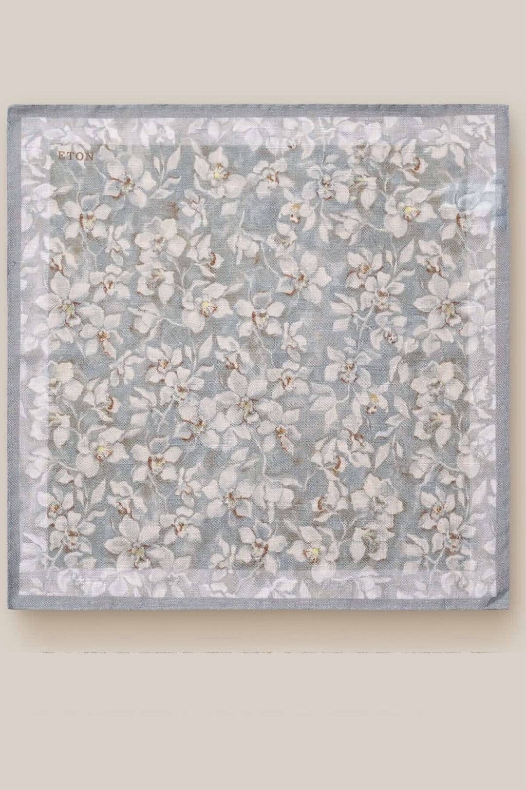 Foulard de poche fleuri en lin, léger et élégant, avec un motif floral sur fond gris.