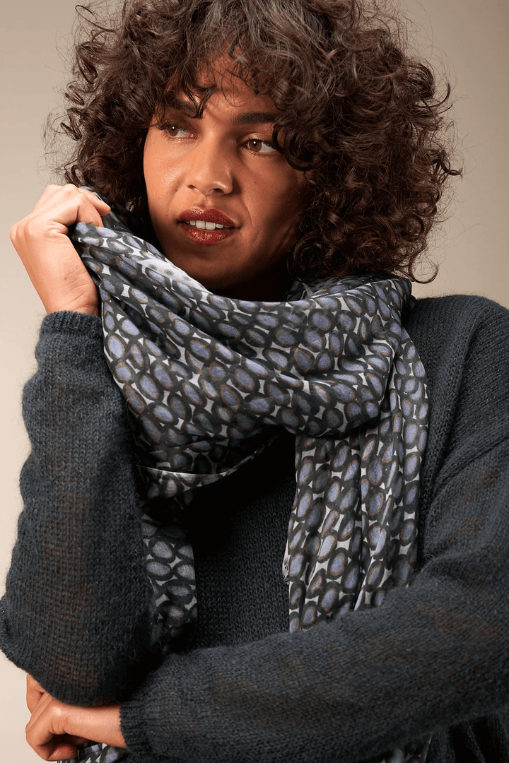 Foulard imprimé élégant, léger et fluide porté par une femme. Accessoire de mode doux offrant confort et sophistication.