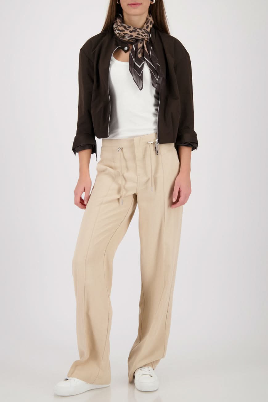 Foulard imprimé léopard artistique porté avec une tenue neutre, ajoutant sophistication et caractère à l'ensemble élégant.