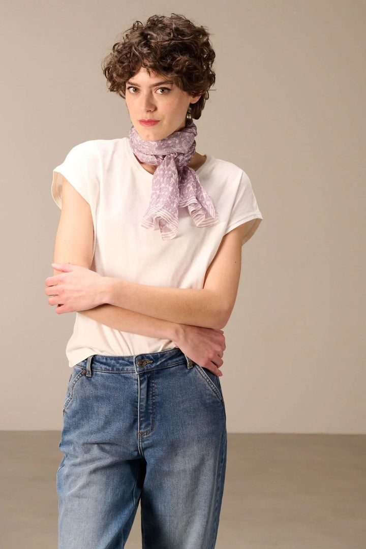 Femme portant un foulard léger imprimé pour un style moderne et élégant, accessoire parfait pour rehausser une tenue.