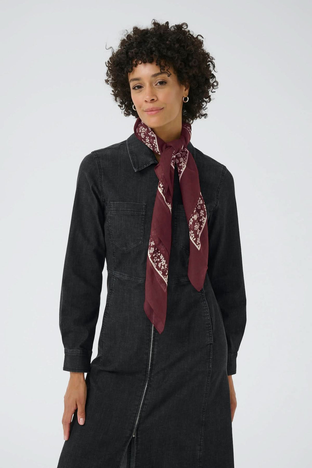 Femme portant le Foulard à motif fleuri Loui, imprimé floral bordeaux, bordure contrastante, élégant et polyvalent.