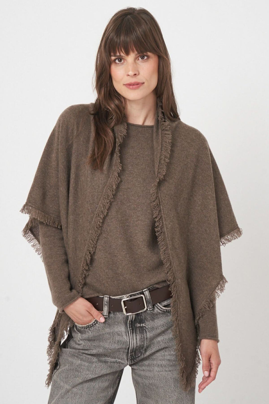 Foulard triangulaire en maille douce marron avec franges, porté élégamment sur une tenue décontractée.