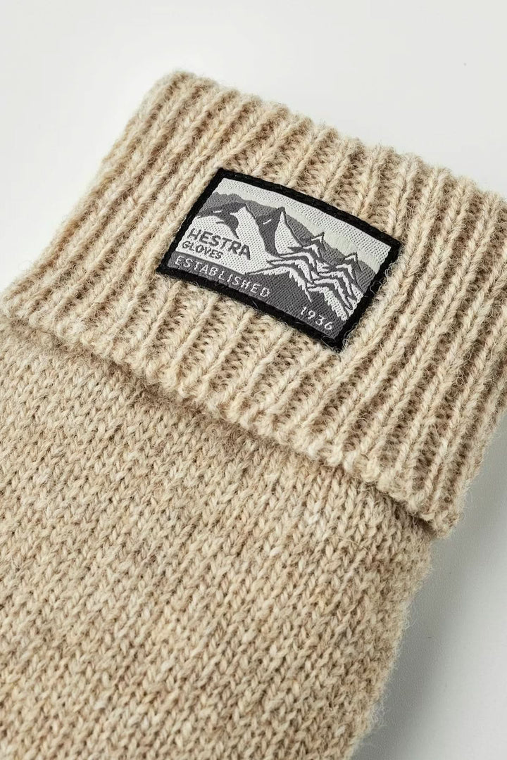 Ganst en maille avec étiquette Hestra, maille beige, poignets côtelés.