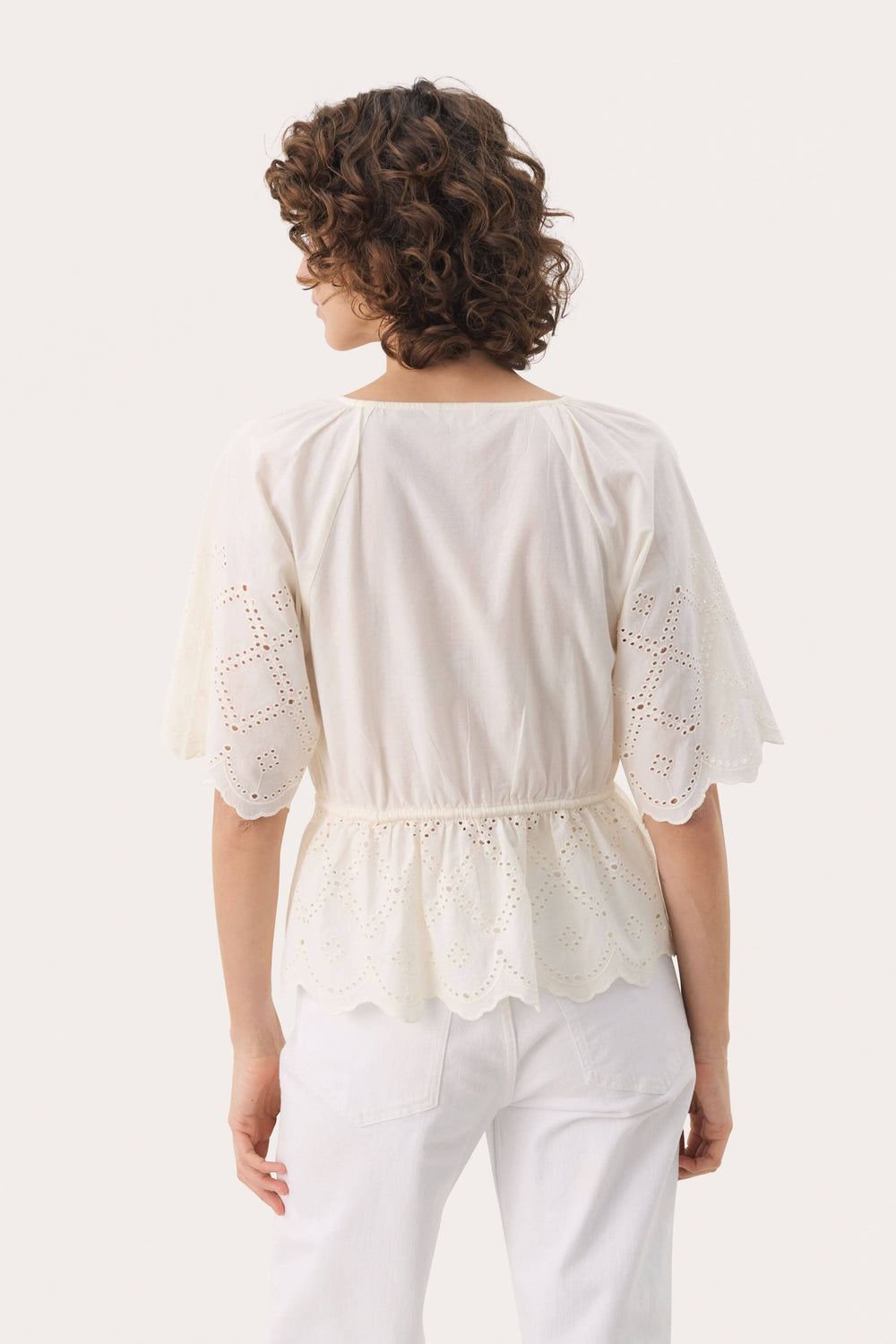 Vue arrière de la blouse Haut Rosalie, en coton léger, avec broderie anglaise et manches amples.