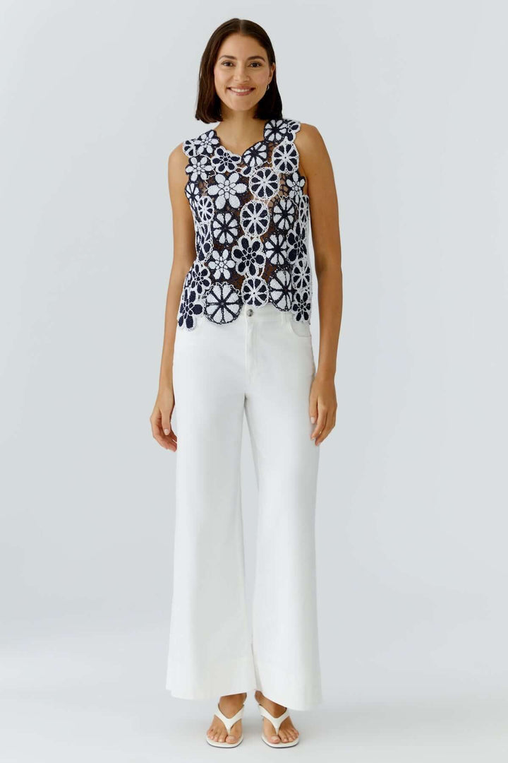 Haut coupe moderne minimaliste porté avec un pantalon blanc, montrant une esthétique épurée et contemporaine pour une garde-robe polyvalente.