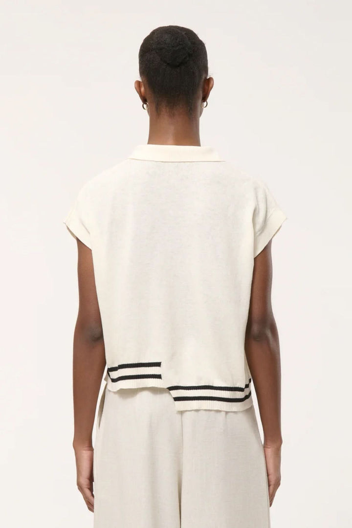 Haut en tricot à rayures contrastantes vu de dos, avec col polo ouvert et fines rayures contrastantes à l’ourlet pour un style moderne.