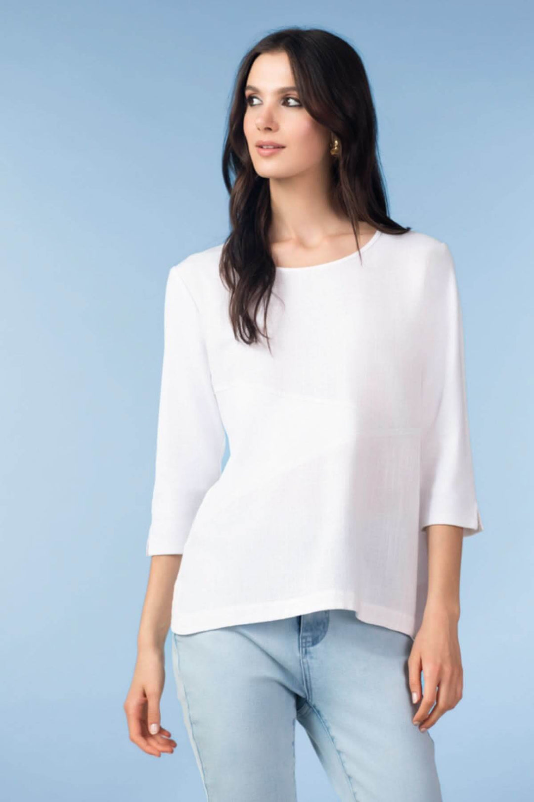 Femme portant haut fluide manches trois-quarts en blanc avec jeans, style décontracté et chic.