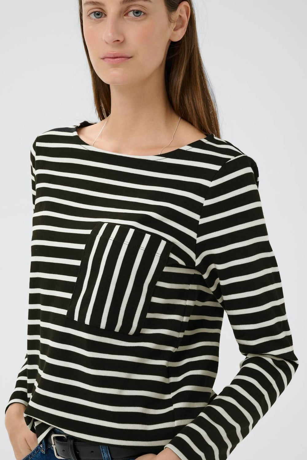 Femme portant le Haut à rayures contrastées Della avec manches longues et poche poitrine graphique. Mode moderne et intemporelle.