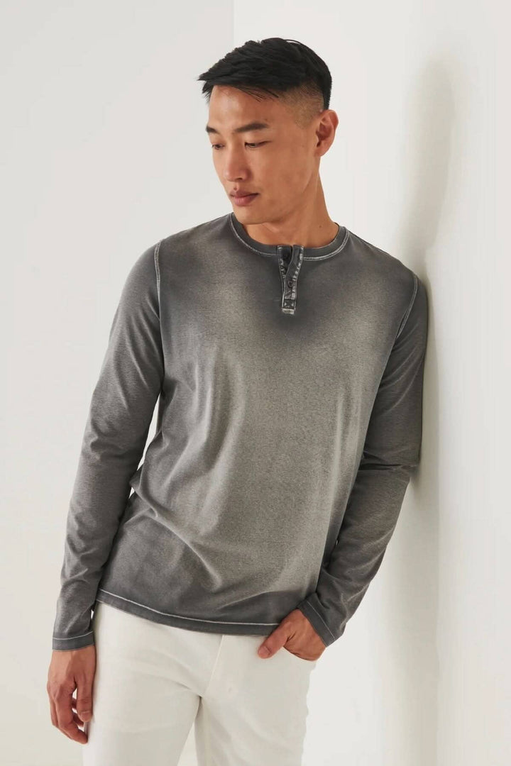 Henley en coton stretch vintage wash, coupe décontractée, couleur dégradée, manches longues, porté par un homme.
