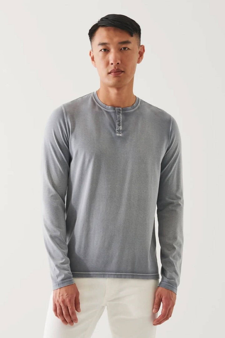 Homme portant un henley en coton stretch vintage wash, à manches longues, couleur gris, avec coupe décontractée.