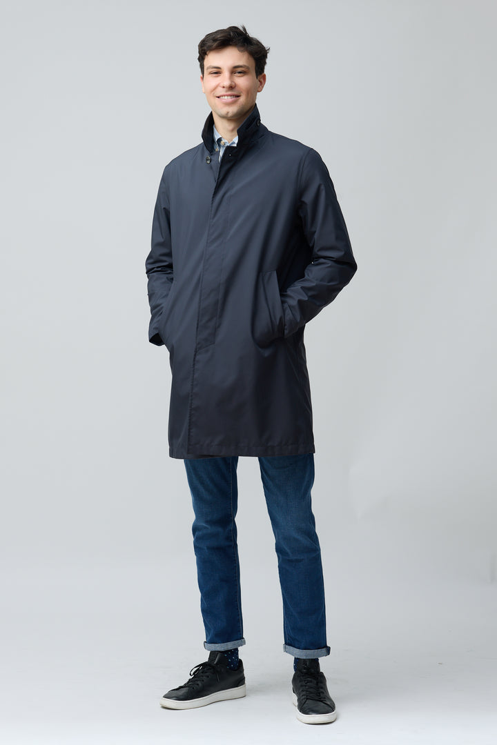 Homme portant un imperméable en microfibre technique avec finition ultra-mat et col chemise, idéal pour une allure moderne et épurée.