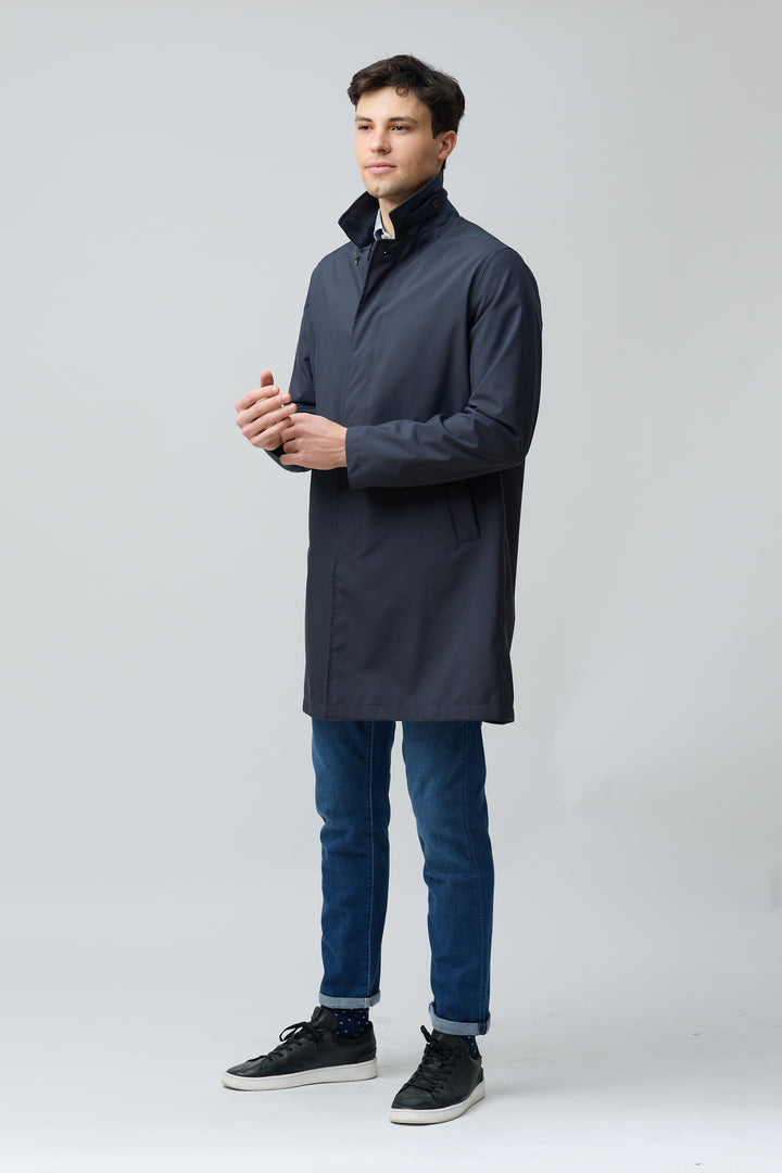 Homme portant un imperméable en microfibre technique au fini ultra-mat, style moderne et raffiné, idéal pour la mi-saison en ville.