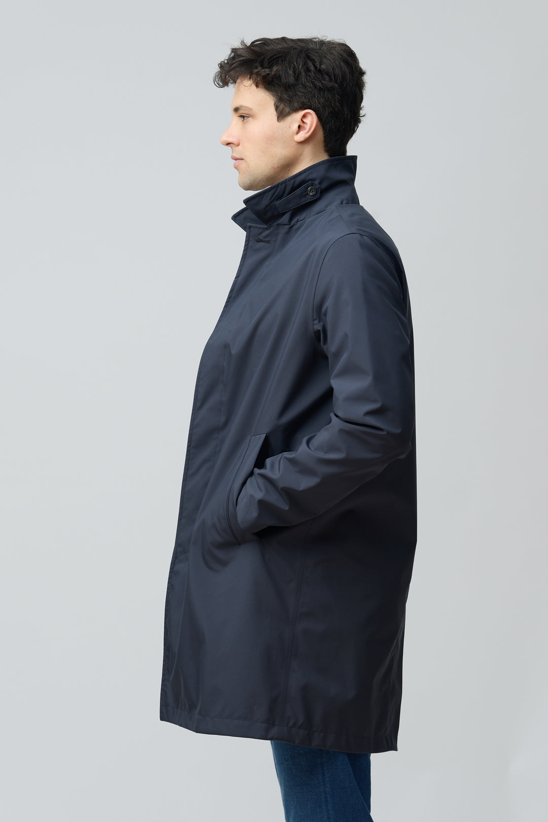 Homme portant un imperméable en microfibre technique avec finition ultra-mat et coupe classique, idéal pour mi-saison.