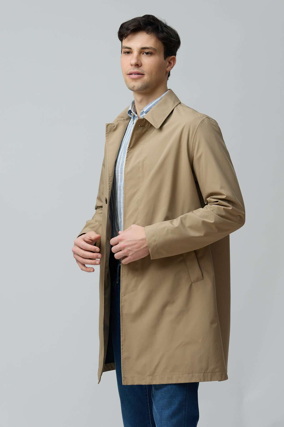 Homme portant un imperméable en microfibre technique beige avec finition ultra-mat, idéal pour la mi-saison, style moderne et épuré.