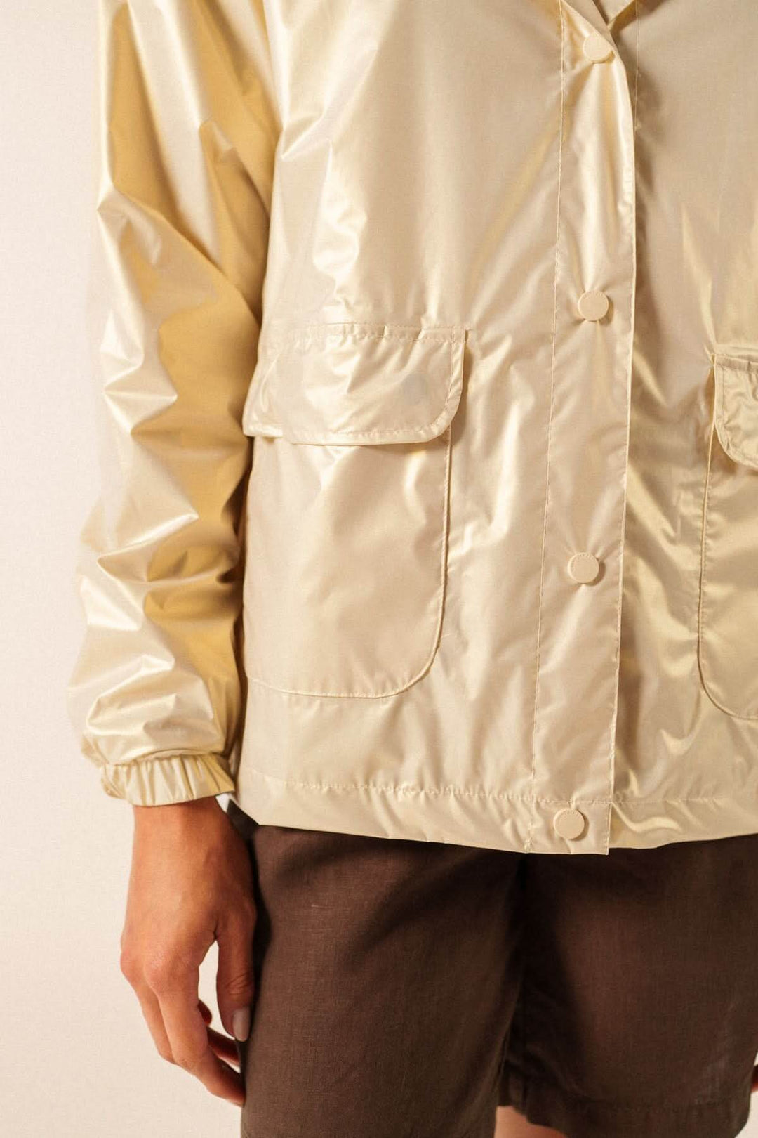 Imperméable léger à capuche STE IRIS en matière déperlante beige, coupe moderne avec poches avant, adapté pour la mi-saison.