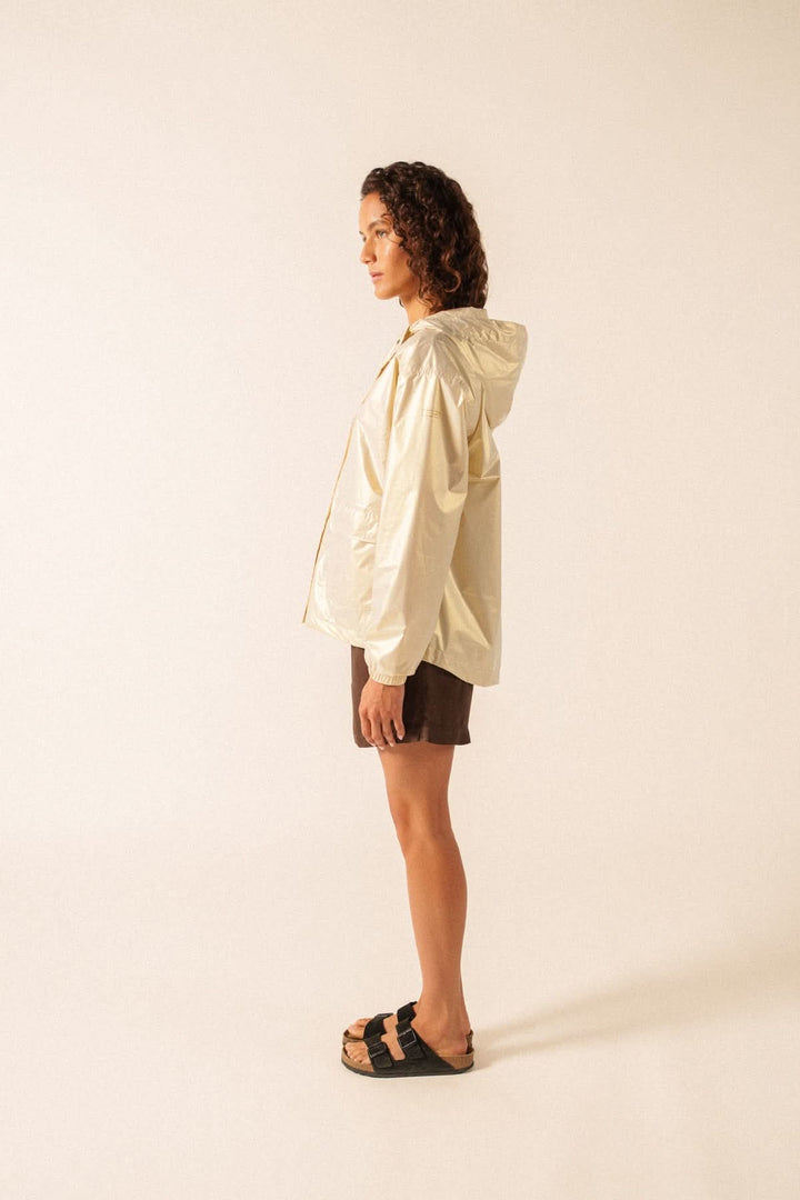 Femme portant un imperméable léger à capuche STE IRIS, vêtement moderne et déperlant idéal pour la mi-saison et un look urbain ou décontracté.