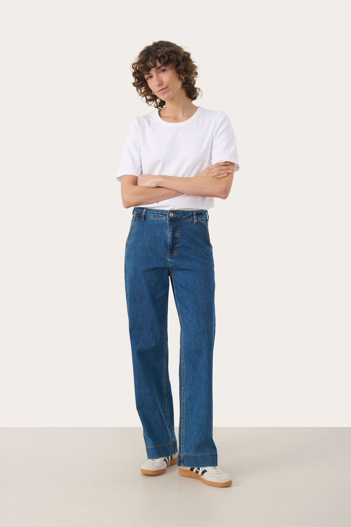 Jean Barba, jean à jambe large moderne et décontracté, porté par une personne vêtue d'un t-shirt blanc, parfait pour un style quotidien.