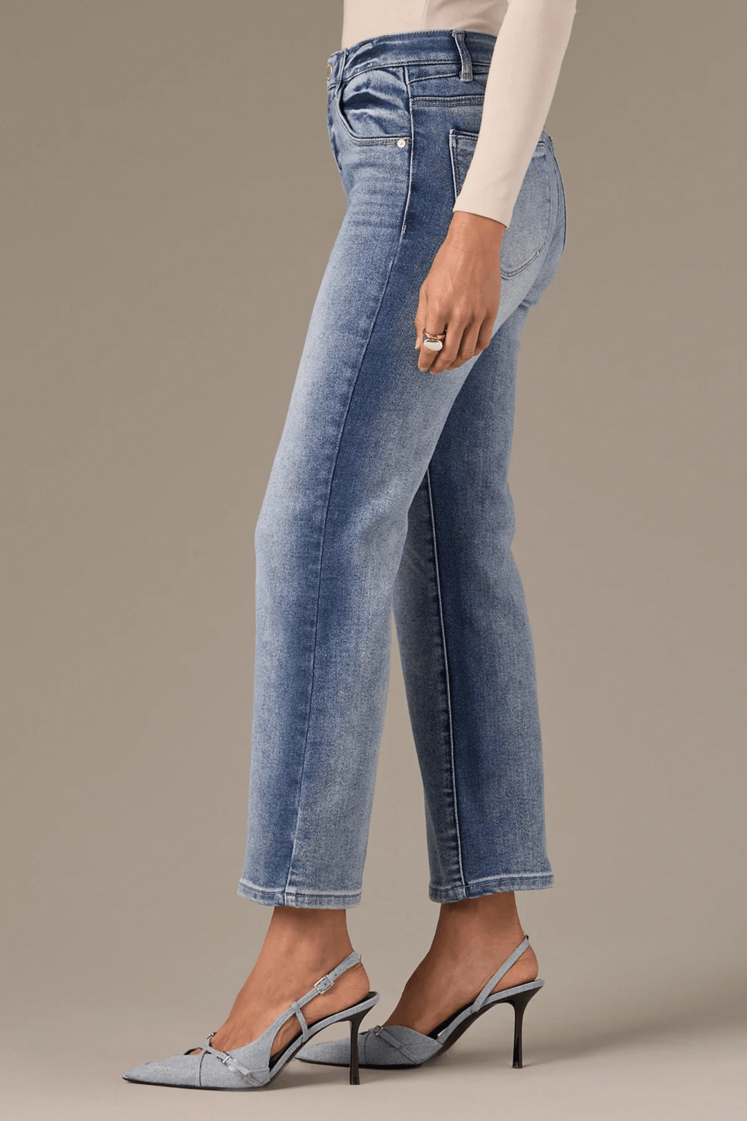 Jean Bennett taille haute évasé avec jambe courte, porté avec des talons pour un look moderne.