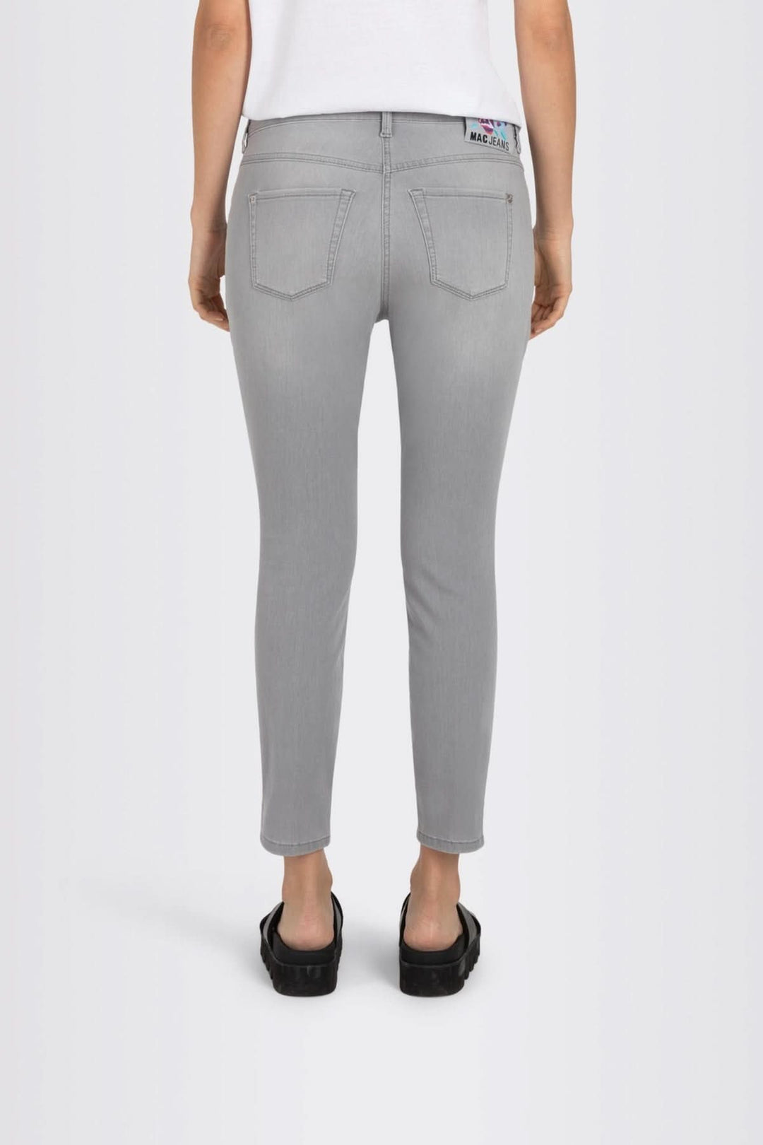 Jean slim gris à coupe ajustée, vue arrière, avec détails fendus et poches, style moderne et confortable.