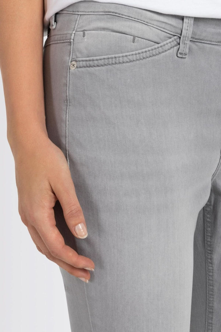 Jean slim gris avec détail de couture, mettant en avant une coupe ajustée et moderne.