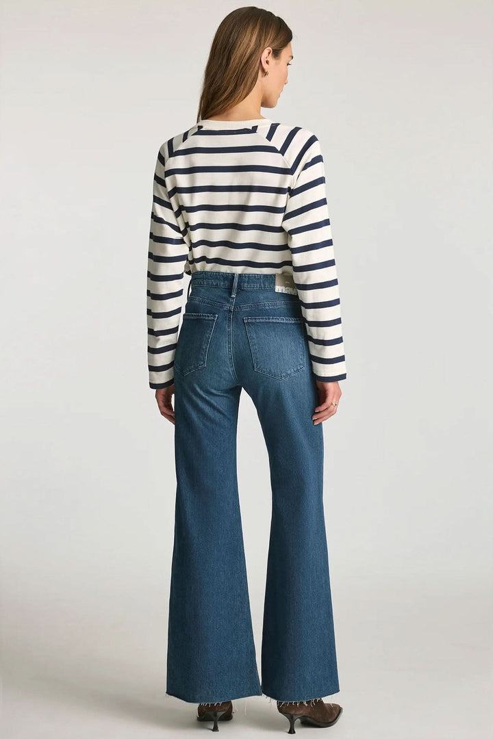 Femme portant Jean Grace jambe large taille mi-haute, denim bleu, avec une coupe fluide et élégante, vue arrière.