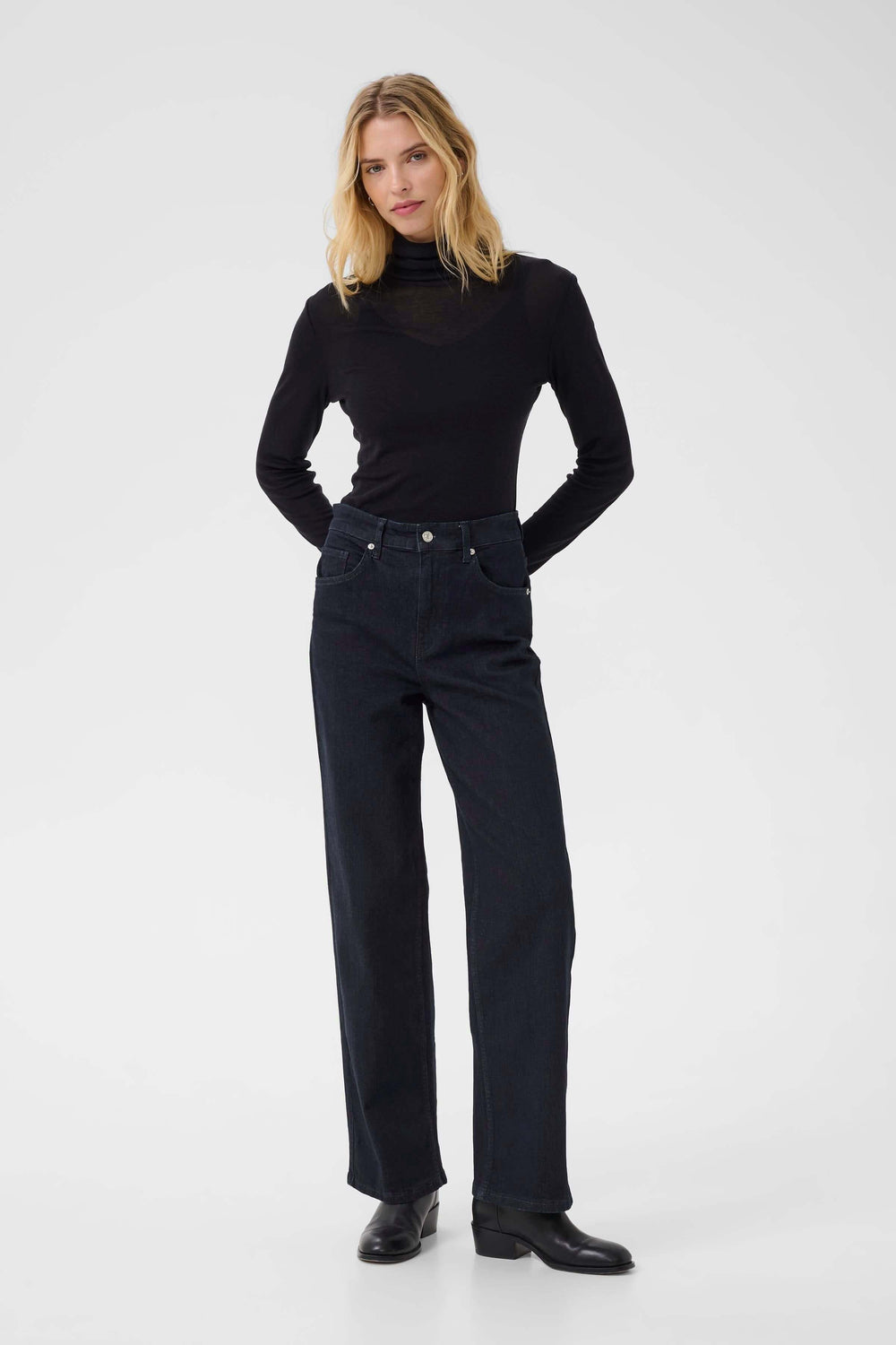 Jean Simona en coupe droite avec taille mi-haute, porté avec un haut noir élégant.