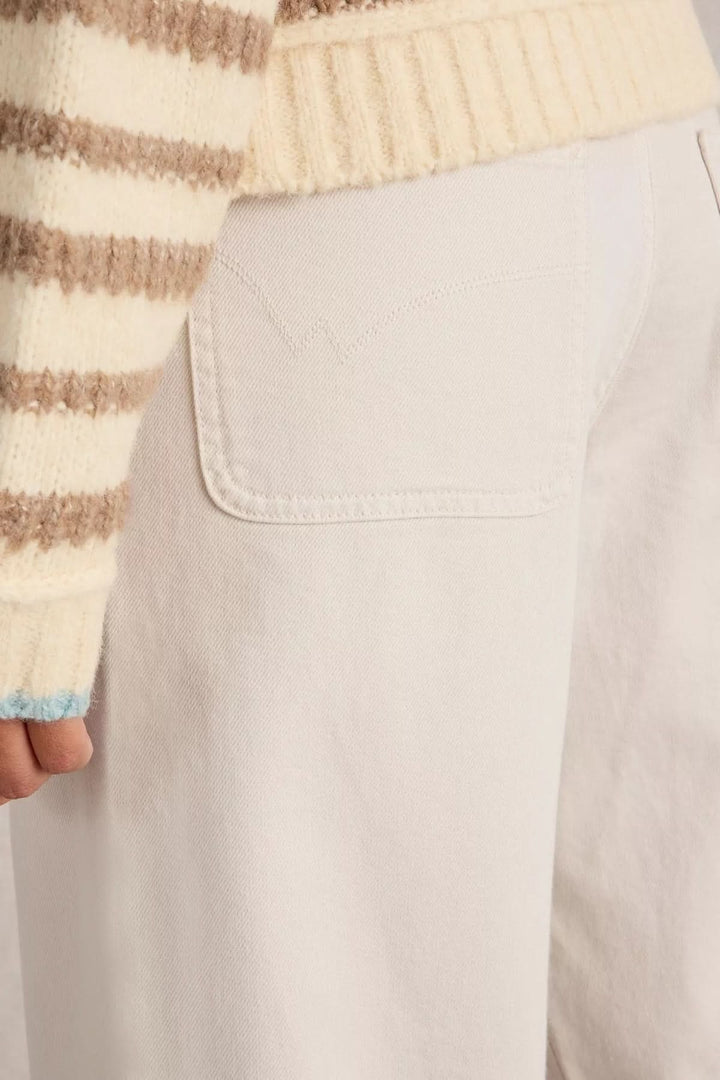 Person wearing Jean Tia court à jambes larges with high-waisted and straight leg design.