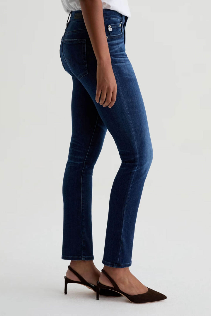 Jean ajusté à taille mi-haute en denim extensible porté avec des talons, vue latérale, coupe flatteuse et confortable.