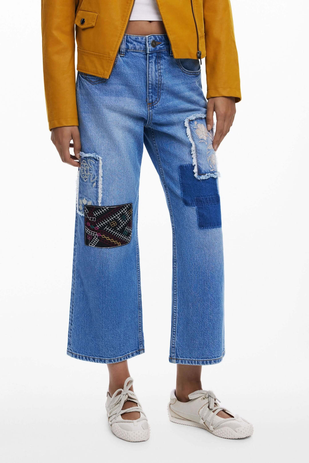 Jean à broderies avec empiècements contrastants et style patchwork, coupe large moderne et créative.
