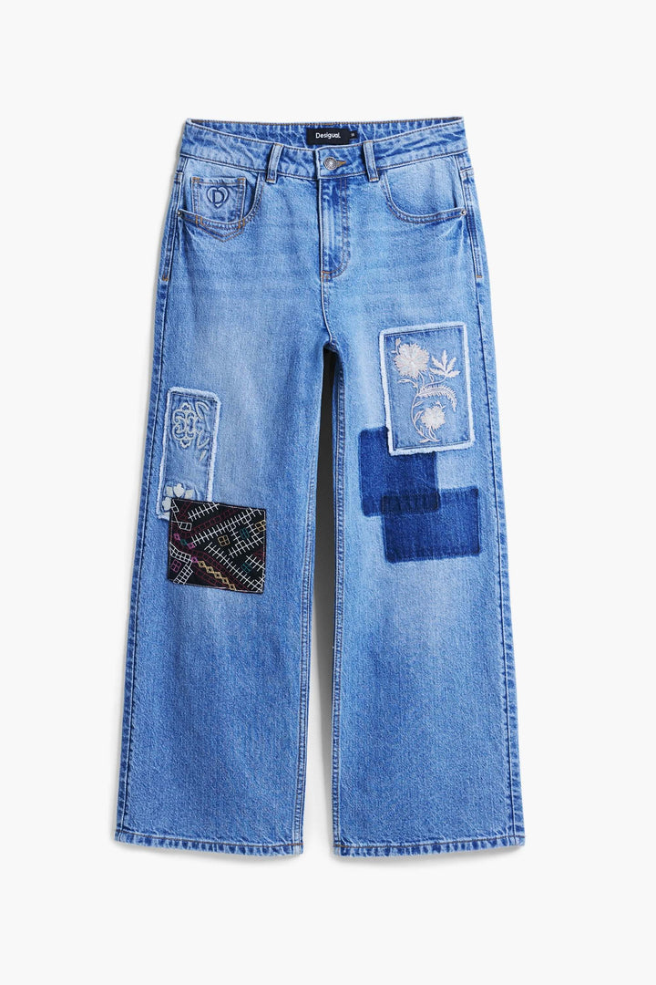 Jean à broderies, jean à jambe large avec empiècements contrastants et broderies texturées pour un style patchwork et créatif.