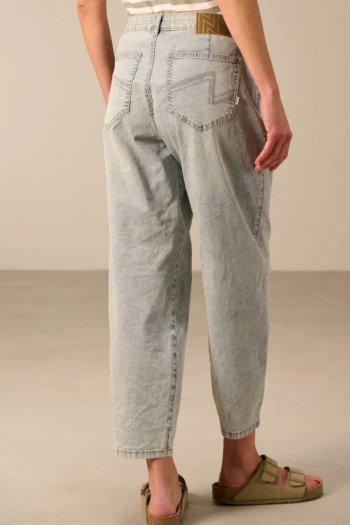 Jean à coupe décontractée en denim souple avec poches latérales et arrière, porté avec sandales, vue de dos.
